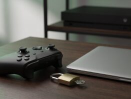 xbox login bild 1 Gamecontroller neben einem Vorhängeschloss mit Schlüssel und einem geschlossenen Laptop als Symbol für den Xbox Login mit dem Microsoft-Konto