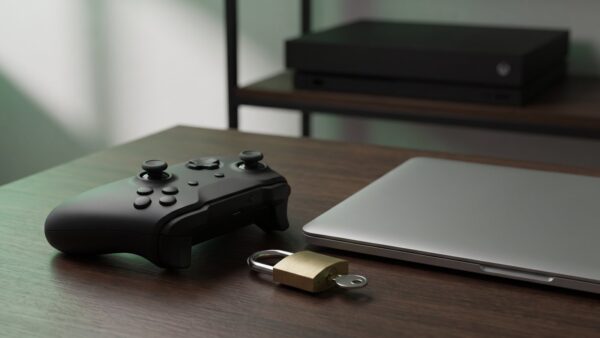 xbox login bild 1 Gamecontroller neben einem Vorhängeschloss mit Schlüssel und einem geschlossenen Laptop als Symbol für den Xbox Login mit dem Microsoft-Konto